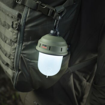 Tourist hanging flashlight attached to backpack outdoor gear close up